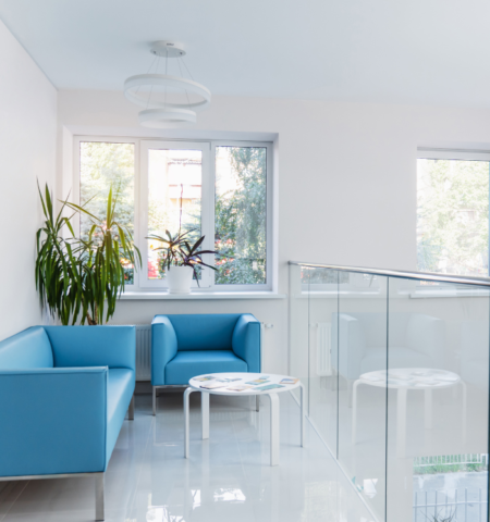 A modern and bright waiting area with blue armchairs and plants inside the IVF center
