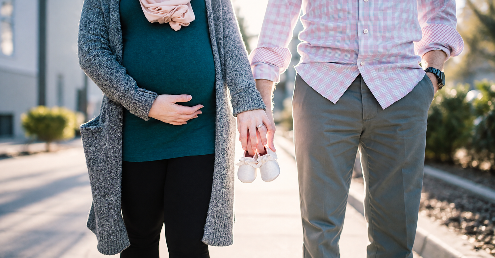 woman and man holding hands and walking in the nature woman is pregnant